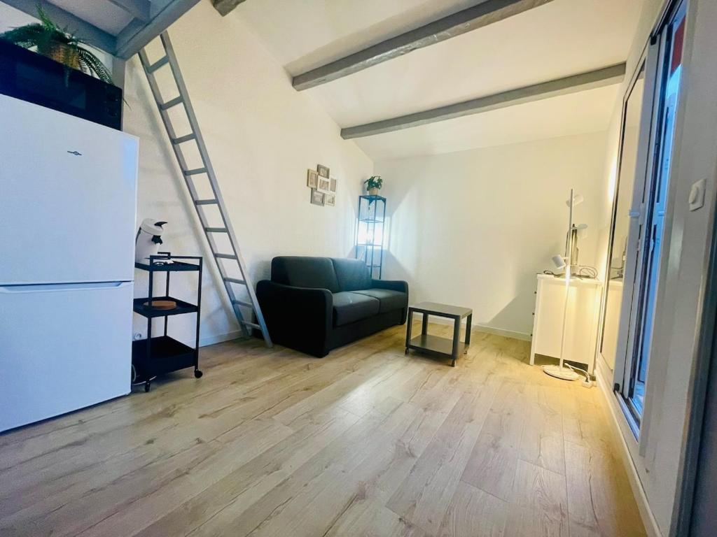 - un salon avec un canapé vert et un escalier dans l'établissement 4 Soleil - Mezzanine Wifi Clim Plage Parking, au Cap d'Agde