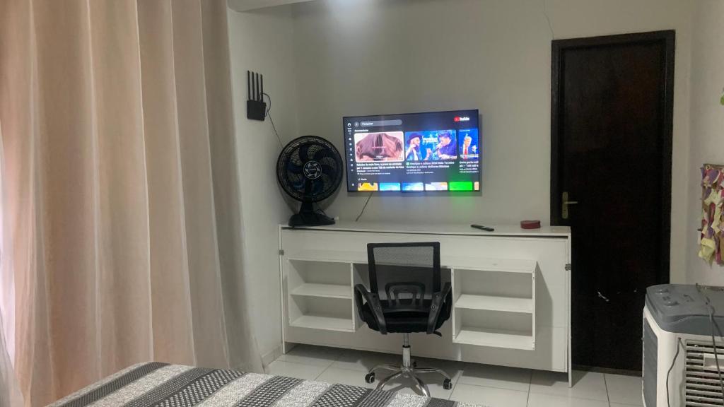 a bedroom with a desk with a chair and a television at Recanto dos Dinos - Apto Térreo in Paty do Alferes