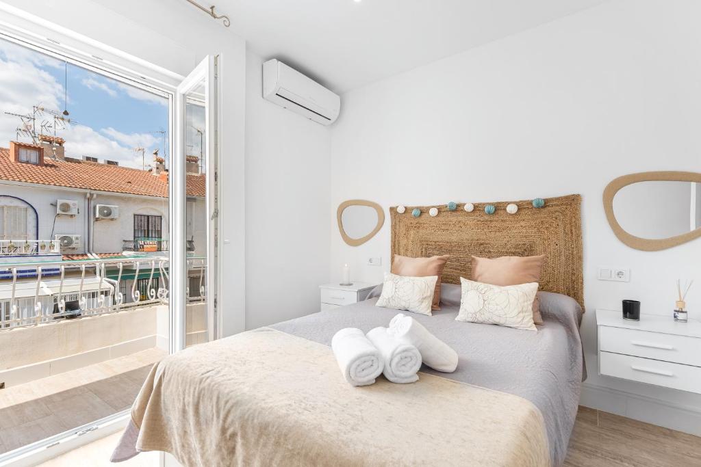 a bedroom with a large bed with white towels on it at Casa Nova - a 2 min de la playa in Santa Pola