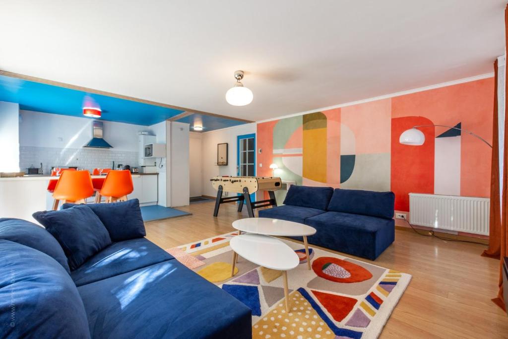 un salon avec un canapé bleu et une table dans l'établissement OIQIA • Pop Factory, à Bussy-Saint-Georges