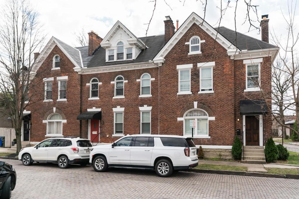 dos autos estacionados frente a una casa de ladrillo en 4 Bedroom Luxe home in Brewery District, en Columbus