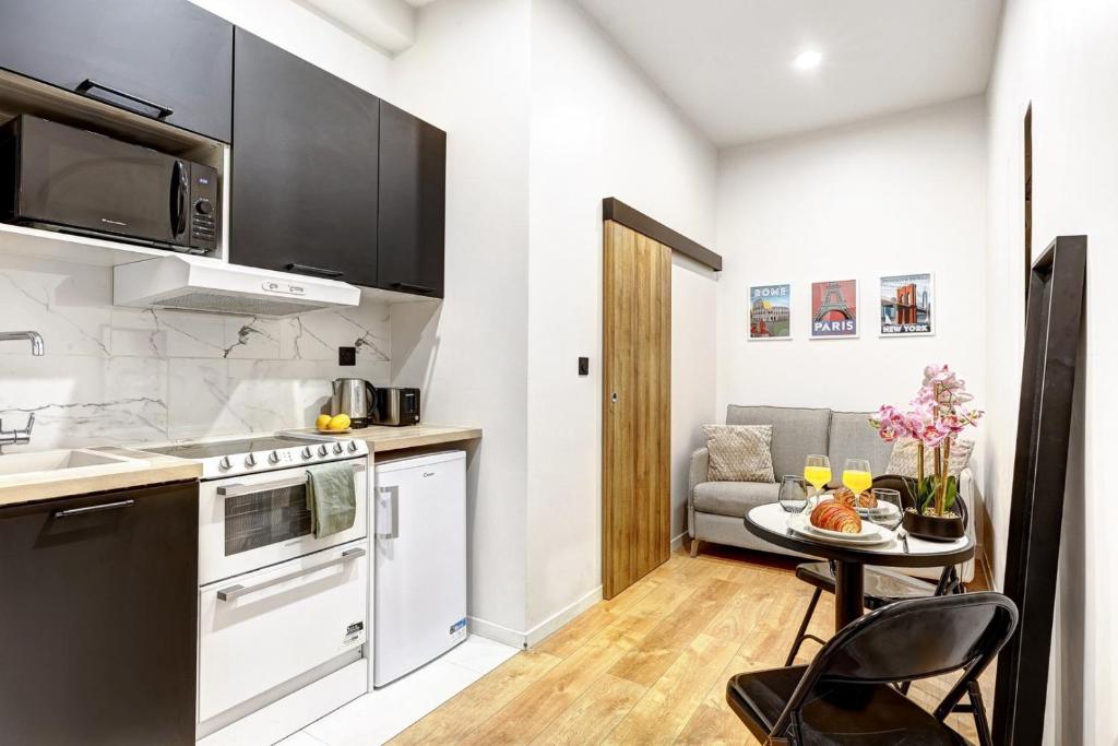 une petite cuisine avec une table dans une pièce dans l'établissement Leo Suite Cozy Studio, à Paris