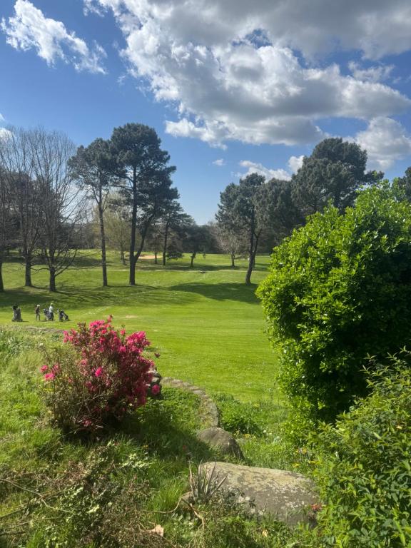 a green field with trees and people in a park at Appartement au cœur du golf in Pont-de-Larn