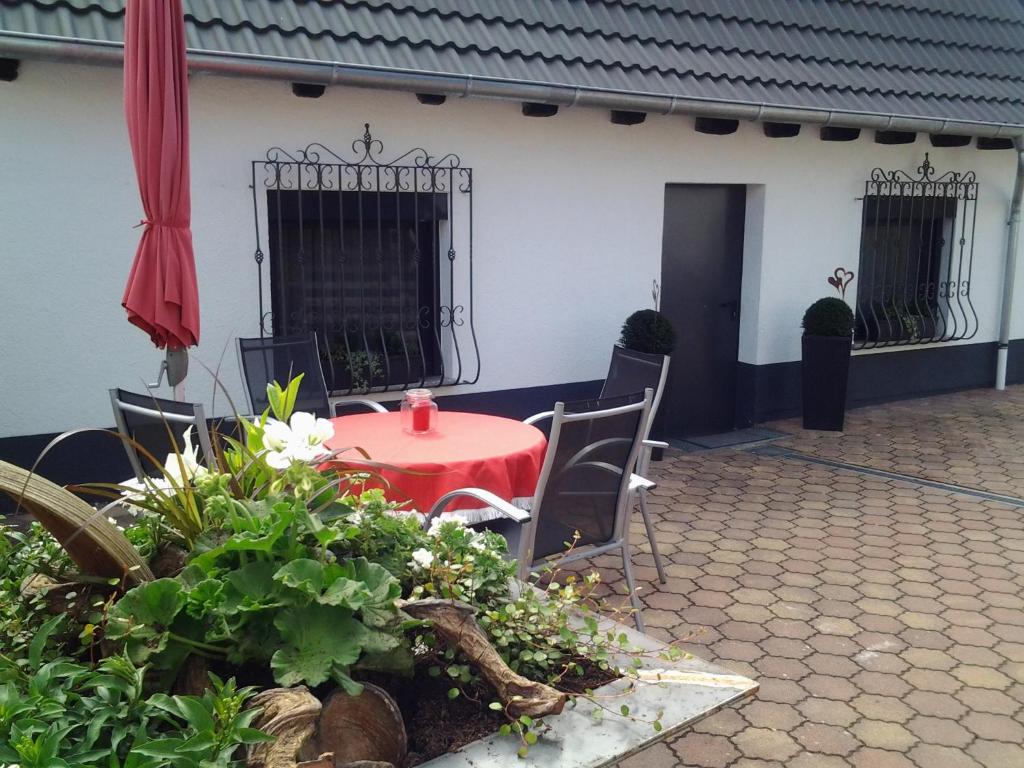 a red table and chairs in a courtyard at Ferienhaus am Erlenbach in Oberhausen