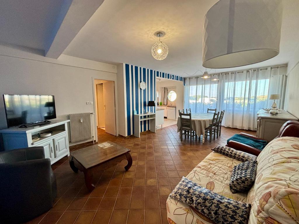 un salon avec un canapé et une télévision dans l'établissement Le Pacifique 6 Pers RDC face a la Mer, à Le Touquet-Paris-Plage