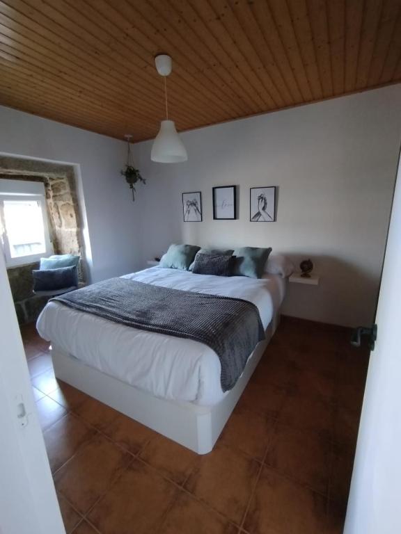 a bedroom with a large white bed in a room at A Casiña de Rande in Redondela