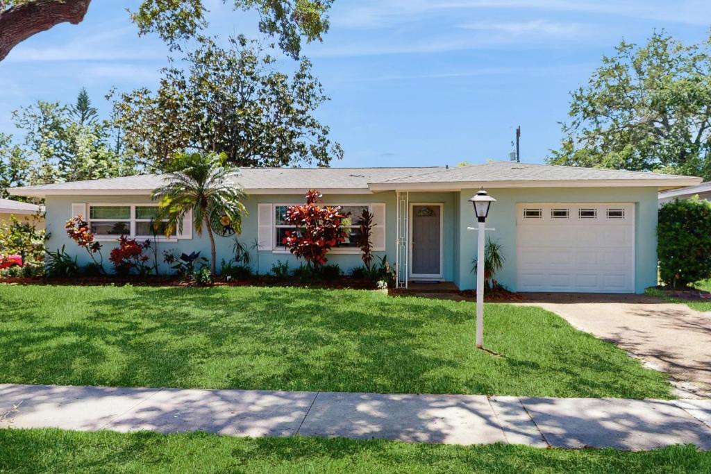 een wit huis met een garage en een oprit bij Relax in Retro in Clearwater