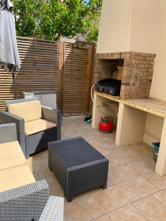 une terrasse avec des chaises et un four à pizza dans l'établissement Le Farniente, à Canet