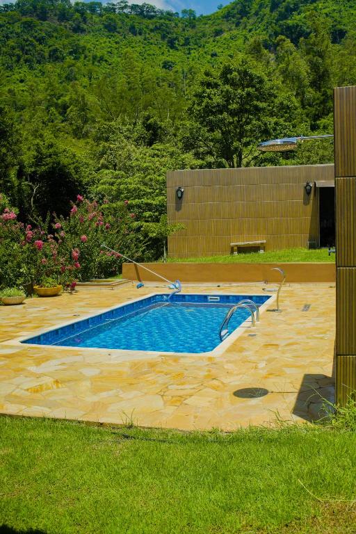 a large swimming pool in a yard with a yard at Chácara Itaqueri Topázio in São Pedro