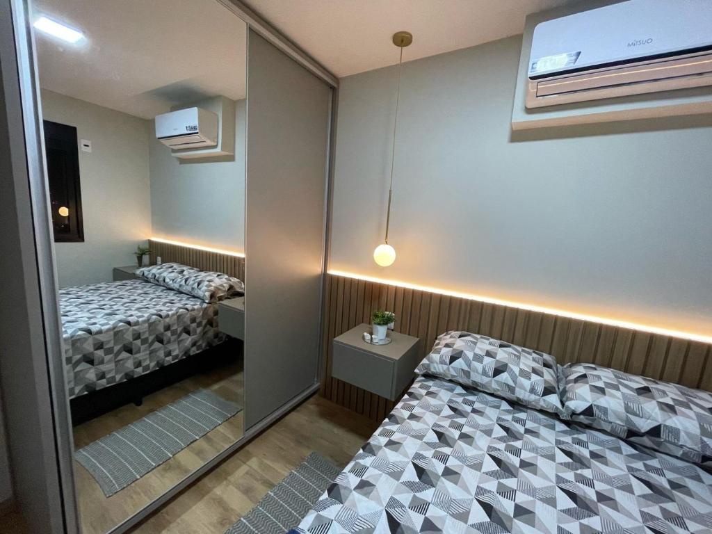 a small room with two beds and a window at Loft SUNSET - 8 ANDAR in Dourados