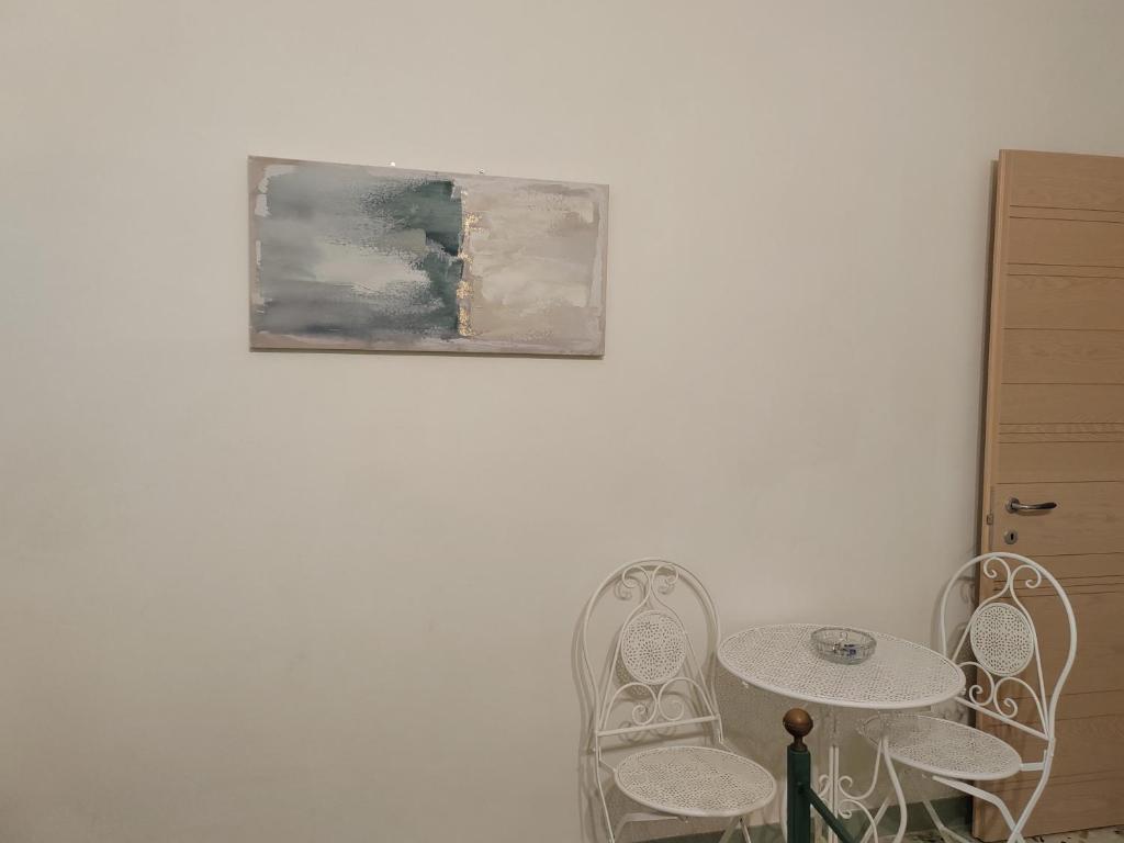 a table and two chairs and a painting on a wall at La casa di Maria in Lipari
