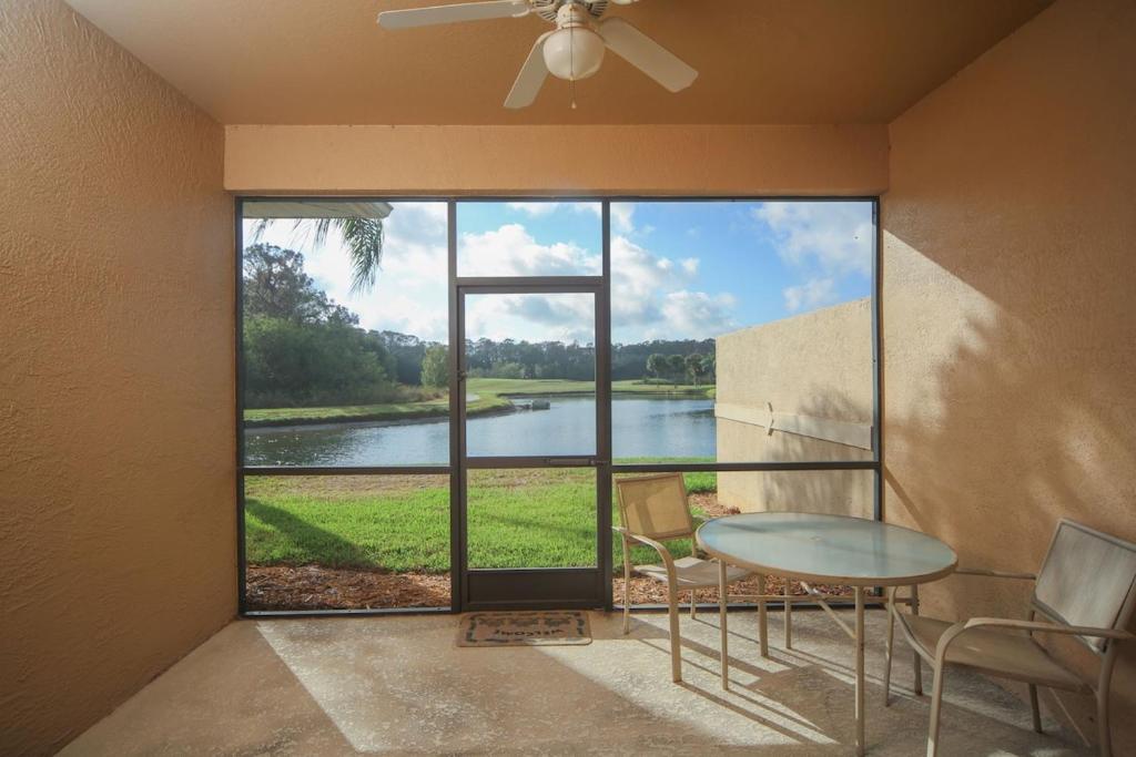 Cette chambre dispose d'une table et offre une vue sur le lac. dans l'établissement Golfer's paradise in resort style Heritage Harbour, à Bradenton