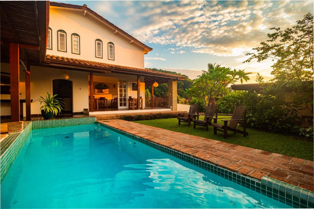 a swimming pool in front of a house at Boutique Hotel Carpe Diem in Paraty