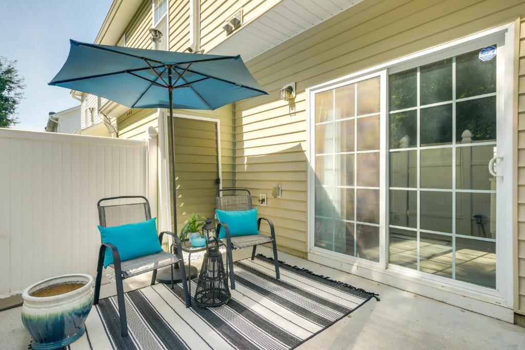 a patio with two chairs and a table with an umbrella at Pets Welcome Townhome with Patio in Raleigh! in Raleigh