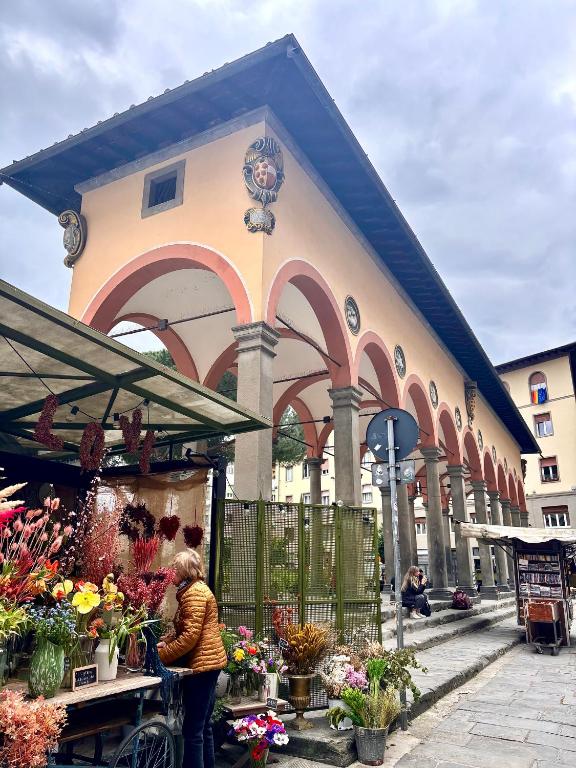 Hotel Affittacamere Medusa, a woman standing in front of a flower market at Affittacamere Medusa in Florence