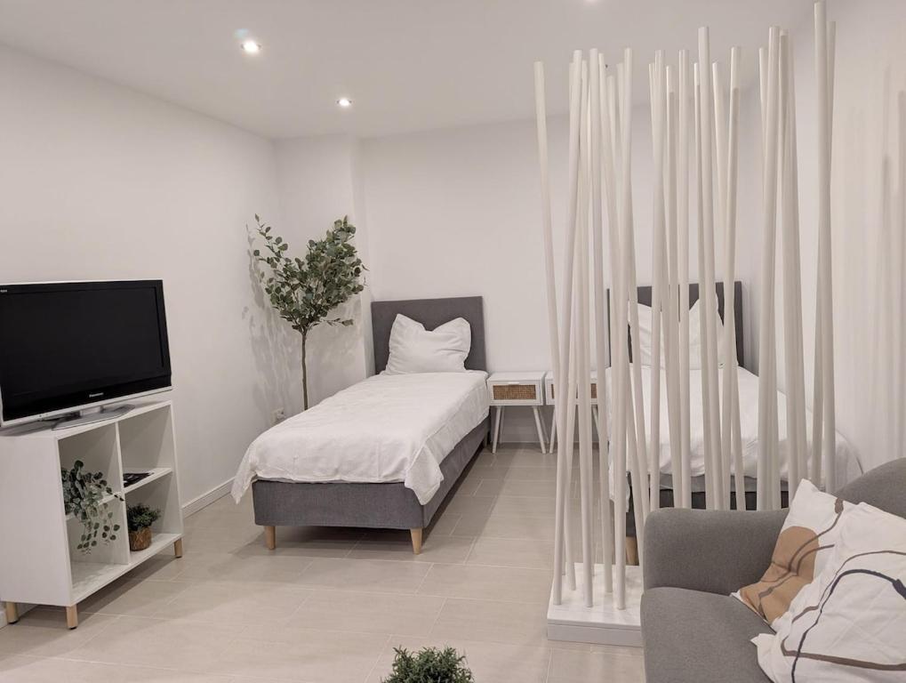 a living room with a bed and a tv at Monteurwohnung Zimmer Pendler Ferien in Gangelt