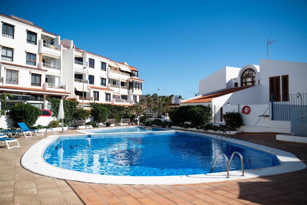 a swimming pool in front of a building at los cristianos pool & sun apartment in Los Cristianos