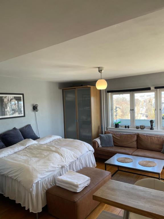 een slaapkamer met een groot bed en een bank bij Frogner Gården Penthouse Terrasse in Oslo
