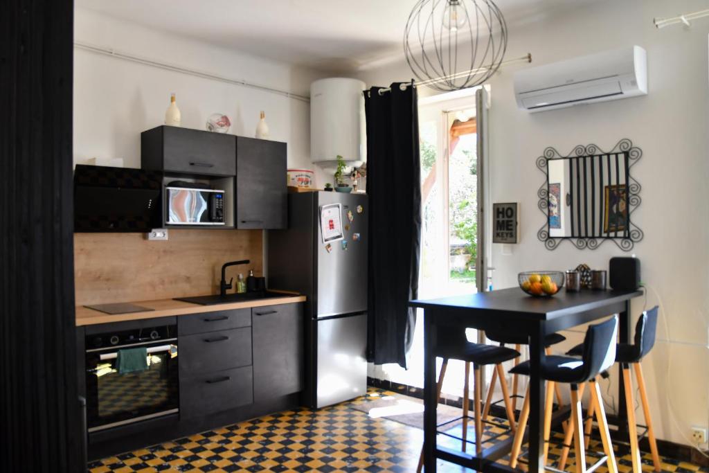 una cocina con una mesa y un refrigerador en Légèreté aux Mûriers, en Le Lavandou