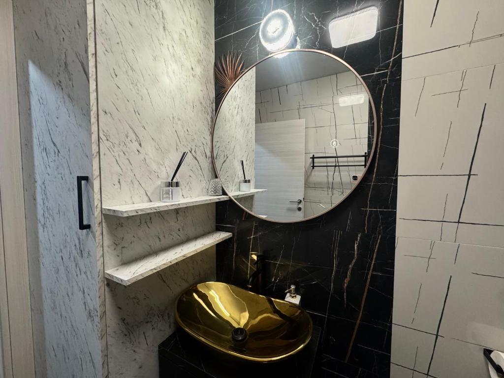 W łazience znajduje się złota umywalka i lustro. w obiekcie Golden Sunset 2 w mieście Nijvice