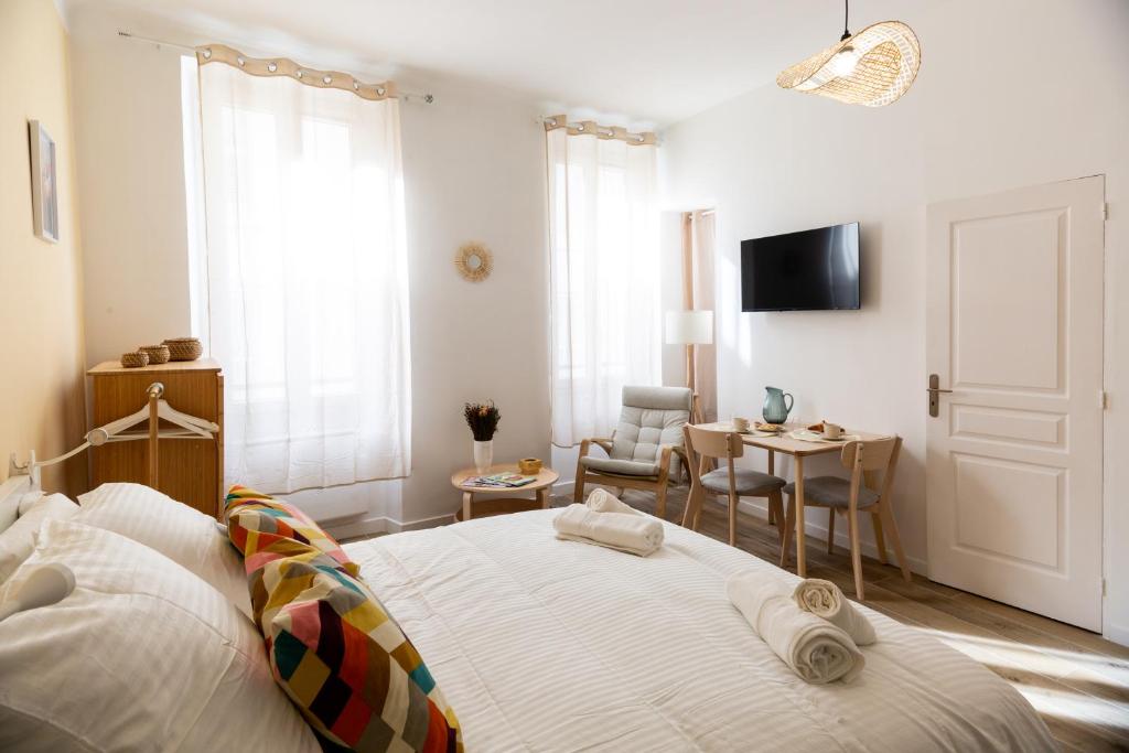 a bedroom with a bed and a table and a chair at Maison Sylvabelle - Confort d'exception - Quartier des Antiquaires - in Marseille