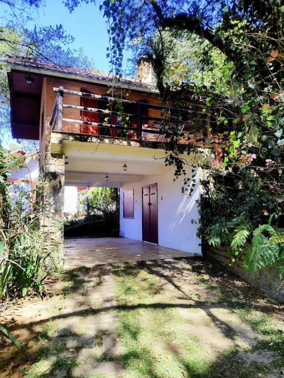 a house with a garage with a driveway at Chale Chez Nous in Monte Verde