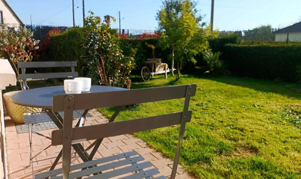 une table et un banc dans une cour dans l'établissement Le Ponthieu de Bayeux, à Bayeux