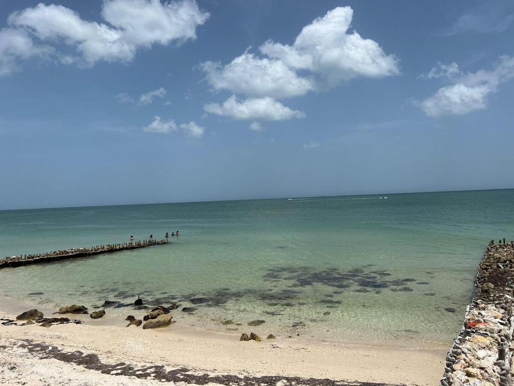 eine Gruppe von Menschen steht auf einem Pier im Meer in der Unterkunft Casazul oceanfront in Chelem! in Chelem