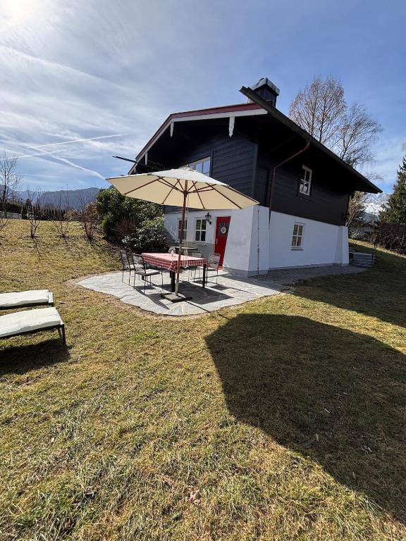a house with a picnic table and an umbrella at Rosenhäusl in Schönau am Königssee