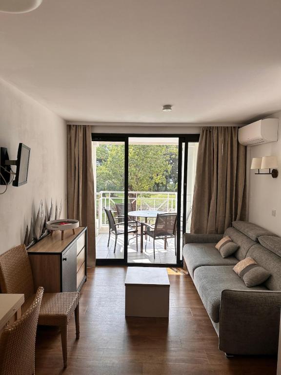 un salon avec un canapé et une table dans l'établissement Appartement 4 personnes ,résidence vue mer et jardin, piscine, parking, à Cannes