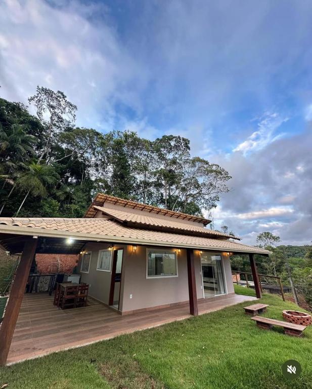 a small house with a wooden deck in a yard at Chácara Vista da Mata in Marechal Floriano