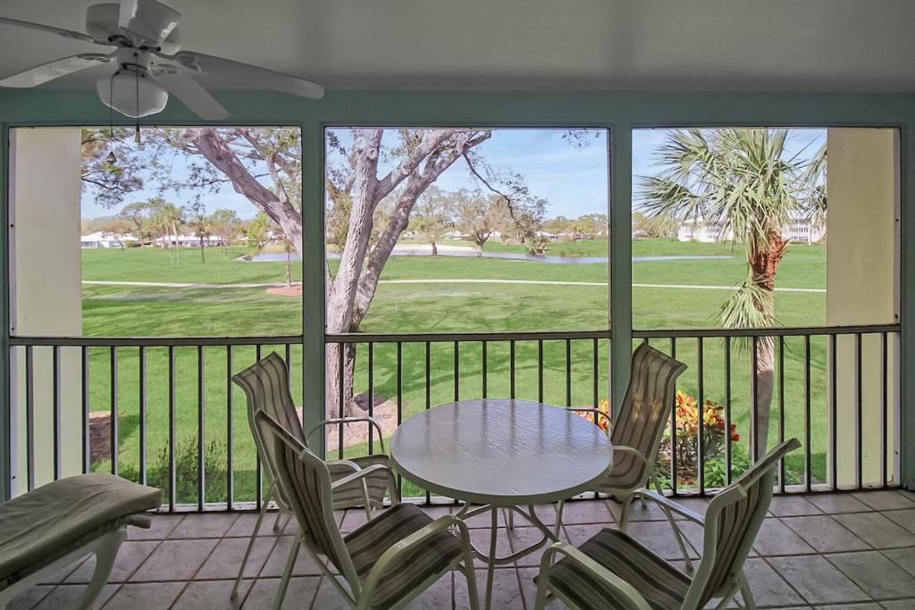 威尼斯Open and airy 2 BR condo in Plantation Golf and Country Club的阳台上配有桌椅的露台