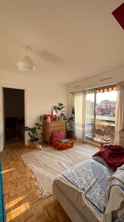 une chambre avec un lit et une grande fenêtre dans l'établissement Appartement ensoleillé et central à Marseille, à Marseille