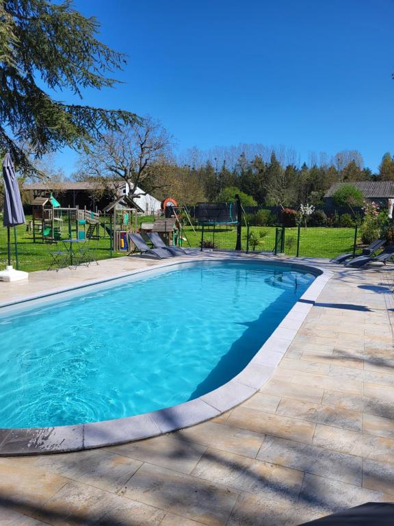 une piscine avec un toboggan et une aire de jeux dans l'établissement A proximité du zoo de beauval, chambre de charme 