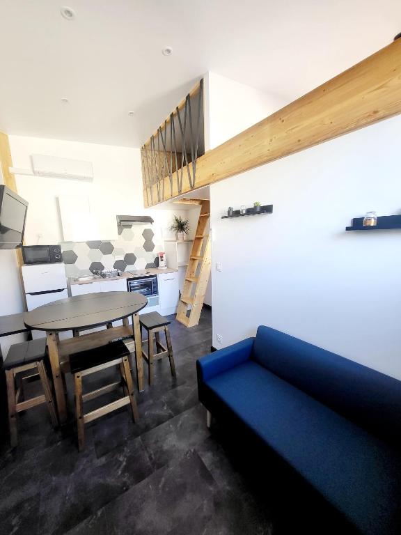 un salon avec un canapé bleu et une table dans l'établissement Maison 4 couchages, à Saint-Léger-sous-Brienne