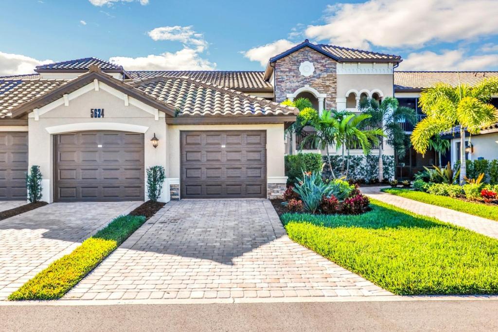 Breathtaking 3 BR condo with lake views in Lakewood National Golf Club - Shades Of Summer في برادنتون: منزل به بابين لوقوف السيارات في ممر