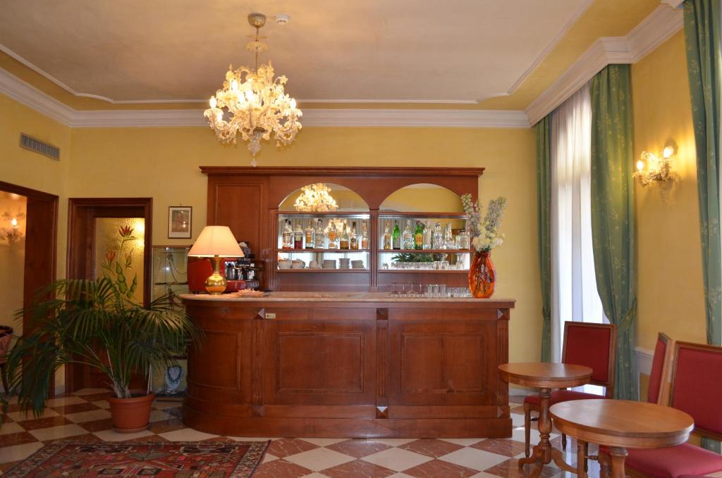 a bar in a restaurant with a chandelier at Hotel Villa Cipro in Venice-Lido