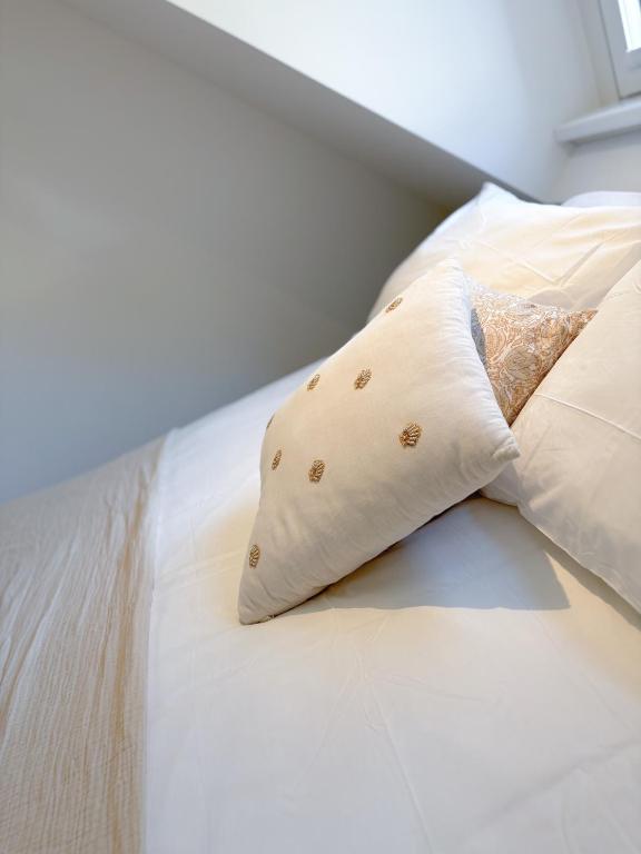 a white bed with two pillows on it at Studio No3 in Katwijk aan Zee