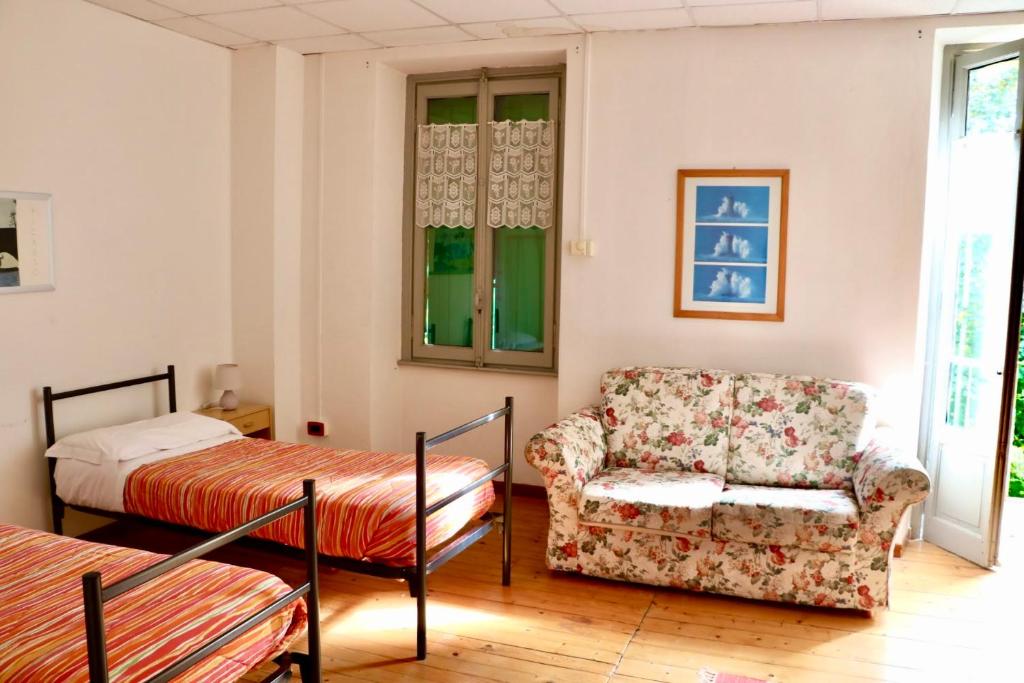 a living room with a chair and a bed at Montino Coliving in Oggebbio