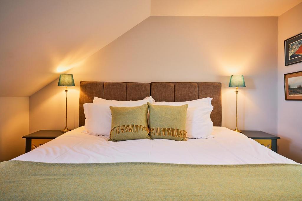 a bedroom with a large white bed with two lamps at Blairgowrie - Cosy terraced cottage sleeps 4 in Blairgowrie