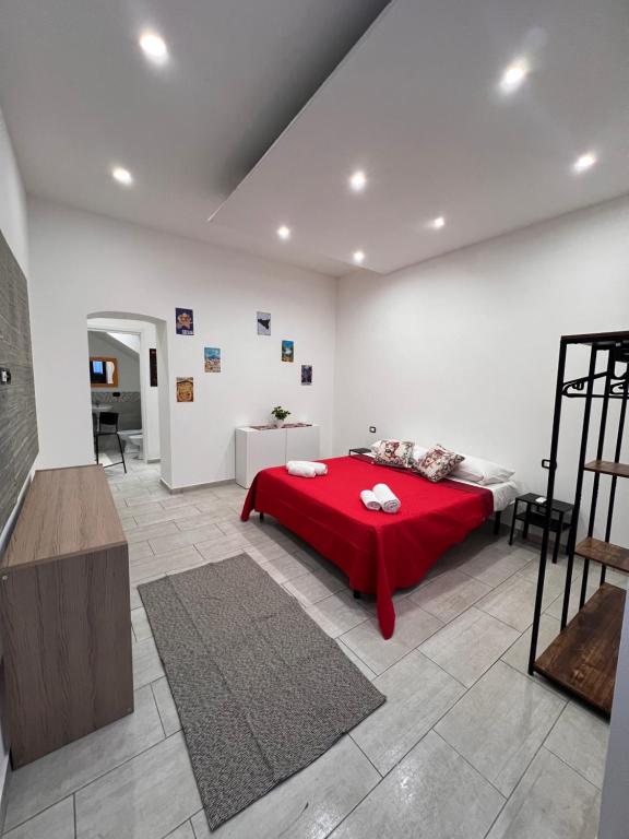 1 dormitorio con 1 cama roja en una habitación blanca en La casa di Giorgia, en Catania