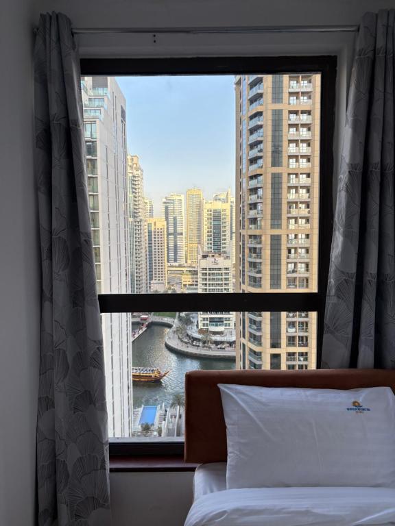 una camera da letto con finestra affacciata sulla città di Horizon Rooms JBR a Dubai