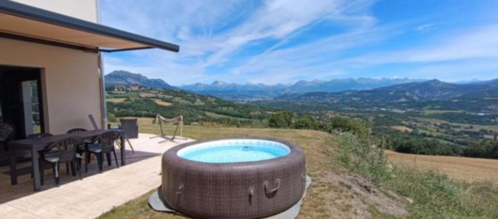 d'un bain à remous sur une terrasse avec vue sur les montagnes. dans l'établissement Maison en montagne au calme, à La Celle-sous-Gouzon