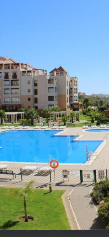 a view of a large swimming pool with buildings in the background at Apartamento Los Pelícanos in Isla Canela