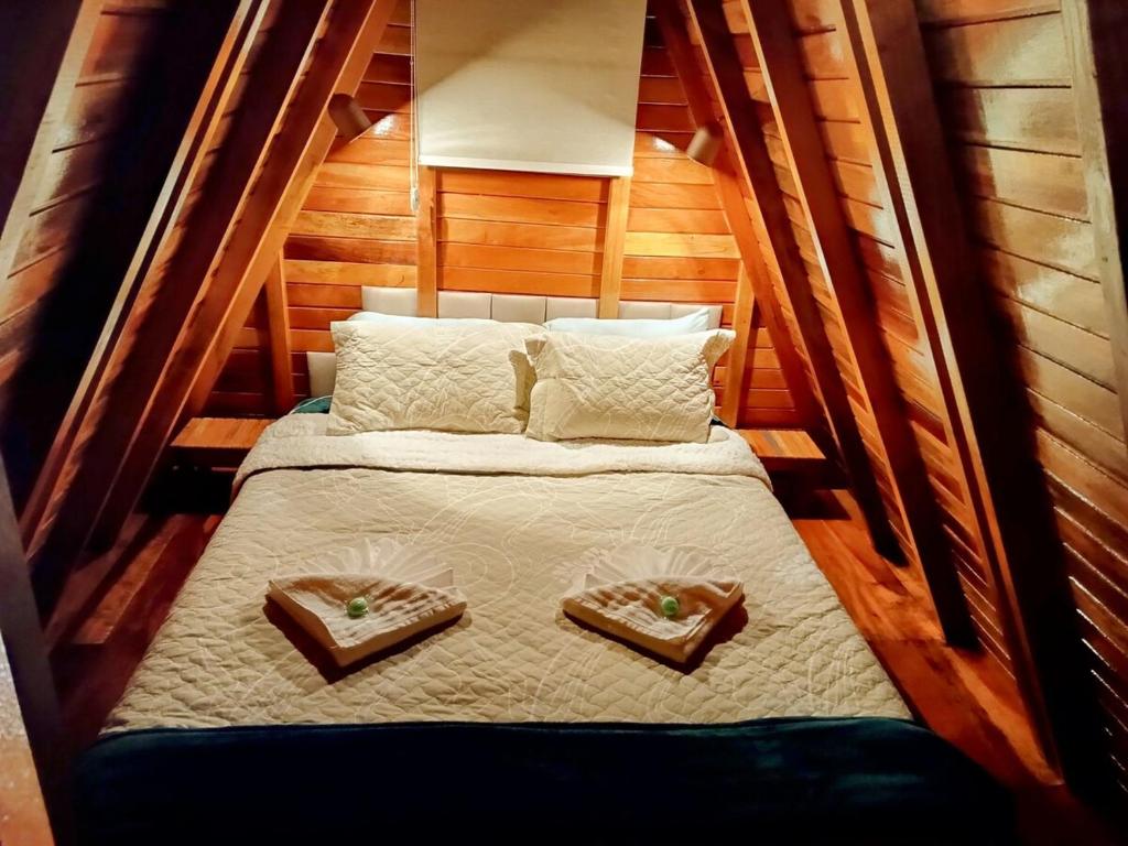 a small bed with two trays on top of it at Chalé Família Rigolo 1 Anthony in Monte Verde