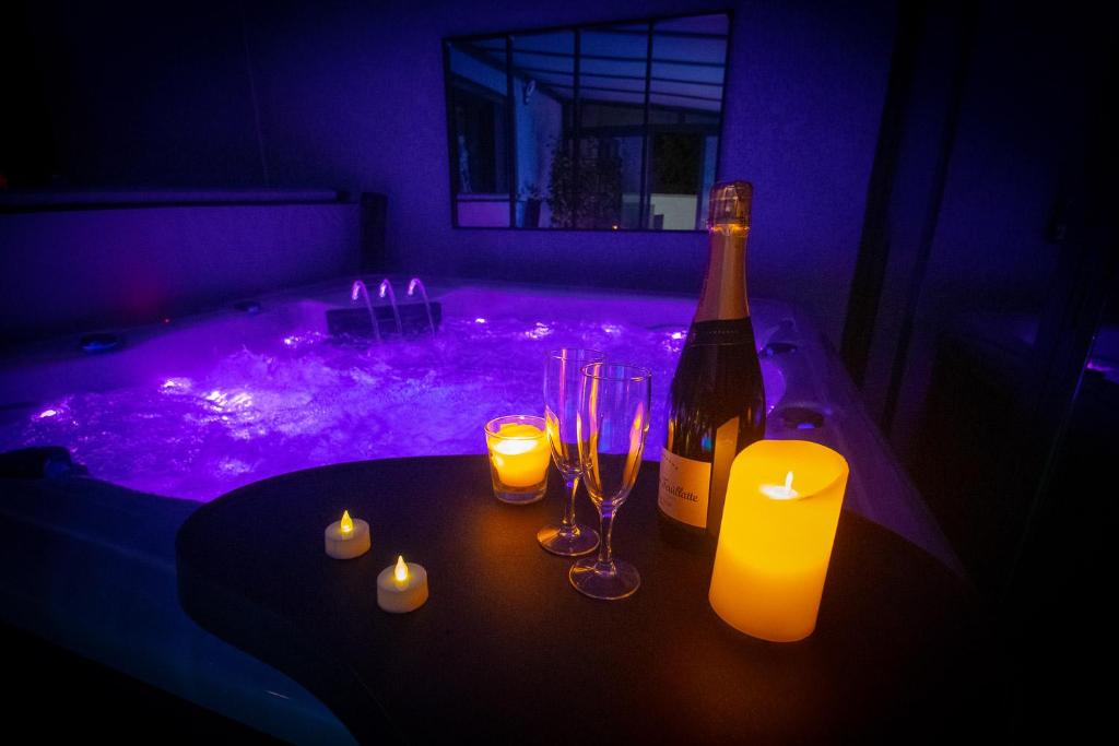 a bottle of wine and candles on a table in a dark room at L'étincelle in Saint-Christol-lès-Alès