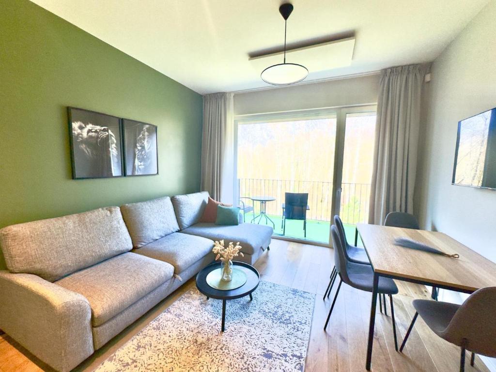 a living room with a couch and a table at Katrina - Kunigiškių apartamentai - Mano Jūra 2 in Palanga