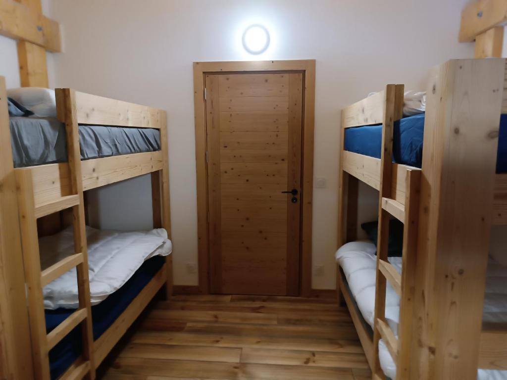 Ce dortoir comprend 2 lits superposés et une porte. dans l'établissement Chalet les angles, aux Angles