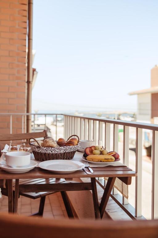 a wooden table with plates of food on a balcony at Moledo's Sea House in Moledo
