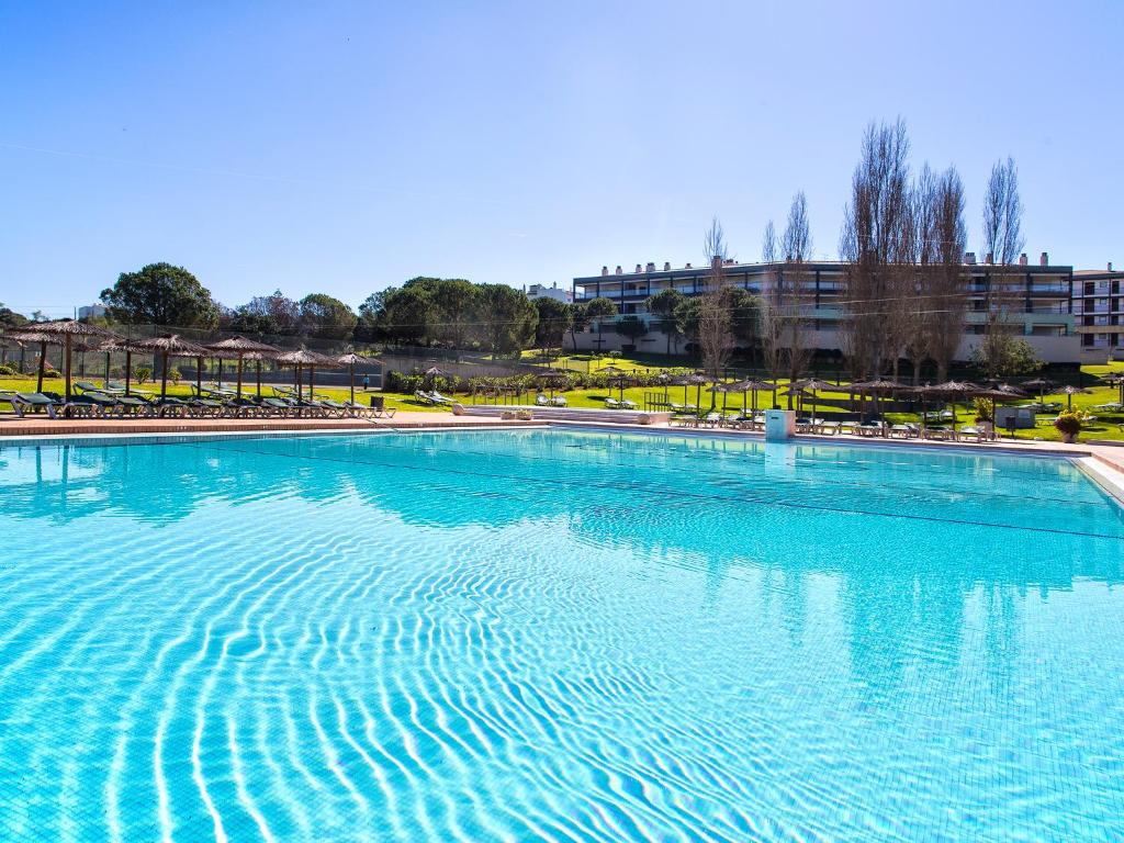 einem großen Pool mit blauem Wasser vor einem Gebäude in der Unterkunft VitaSol Park in Lagos